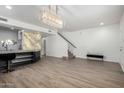 An open-concept living area with a luxury island/bar, modern light fixtures, and staircase at 21655 N 36Th Ave # 131, Glendale, AZ 85308