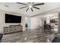 Open-concept living space showcasing tile floors, a large TV, and seamless flow to the dining area at 25420 W Park Ave, Buckeye, AZ 85326