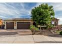 Charming home with a three-car garage, stone accents, and a well-manicured front yard at 2741 E Odessa St, Mesa, AZ 85213