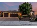 Charming home with a three-car garage, stone accents, and a well-manicured front yard at 2741 E Odessa St, Mesa, AZ 85213