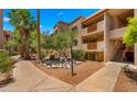 Exterior view of the residence shows balconies, stairs, and lush greenery with accent pond at 3031 N Civic Center Plz # 355, Scottsdale, AZ 85251