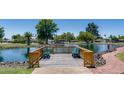 Scenic view of the pond with a wooden viewing deck, benches, and surrounding greenery on a sunny day at 3307 E Kings Ave, Phoenix, AZ 85032