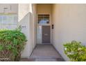 Inviting entryway featuring a secure screen door and lush greenery surrounding the entrance at 3837 E Windsong Dr, Phoenix, AZ 85048