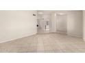 Open-concept living room with neutral tile flooring and modern lighting at 4510 N 105Th Ave, Phoenix, AZ 85037
