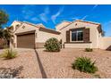 Charming single-story home with a brown two car garage, desert landscaping and a walkway to the front door at 4639 E Cabrillo Dr, Gilbert, AZ 85297