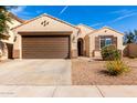 Charming single-story home with a brown two car garage, desert landscaping and a walkway to the front door at 4639 E Cabrillo Dr, Gilbert, AZ 85297