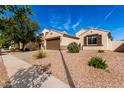 Charming single-story home with a brown two car garage, desert landscaping and a walkway to the front door at 4639 E Cabrillo Dr, Gilbert, AZ 85297