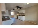 Bright kitchen featuring white cabinets, tile flooring and a ceiling fan at 4721 N 55Th Dr, Phoenix, AZ 85031