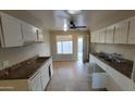 Bright kitchen featuring white cabinets, tile flooring and access to backyard at 4721 N 55Th Dr, Phoenix, AZ 85031