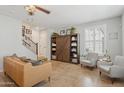 Bright living room featuring neutral walls, tile flooring, ceiling fan, and staircase to the second floor at 4772 E Portola Valley Dr # 102, Gilbert, AZ 85297