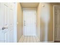 Bright entryway with tile flooring and a white front door creating a welcoming first impression at 5401 E Van Buren St # 3048, Phoenix, AZ 85008