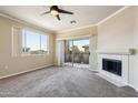 Cozy living room with a fireplace, a ceiling fan, and a sliding glass door leading to a private balcony at 5401 E Van Buren St # 3048, Phoenix, AZ 85008