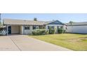 Single-story home with a large driveway, desert landscaping, and blue trim at 5437 E Pinchot Ave, Phoenix, AZ 85018
