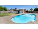 Backyard showcasing an in-ground swimming pool with concrete surround and rear pool house at 5504 N 69Th Ave, Glendale, AZ 85303