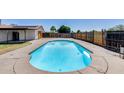 Inviting backyard pool surrounded by a concrete deck and wooden fencing at 5504 N 69Th Ave, Glendale, AZ 85303