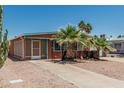 Cozy home with rock landscaping, palm trees, covered patio and neutral exterior paint at 7326 E Juanita Ave, Mesa, AZ 85209