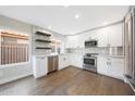 A kitchen with white cabinets, stainless steel appliances, and a view to the outside at 7535 W Kimberly Way, Glendale, AZ 85308