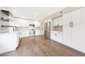 Bright kitchen featuring white cabinets, stainless steel appliances, and hardwood floors at 7535 W Kimberly Way, Glendale, AZ 85308