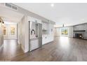 Open-concept living space with hardwood floors and stainless steel refrigerator at 7535 W Kimberly Way, Glendale, AZ 85308