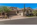 Attractive beige single-Gathering home featuring desert landscaping, a tile roof, and a brick-paved driveway at 8055 E Jaeger St, Mesa, AZ 85207