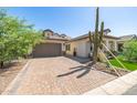 Charming single-Gathering home featuring desert landscaping, brick driveway, and a two-car garage at 8055 E Jaeger St, Mesa, AZ 85207