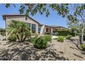 Inviting backyard with patio seating, lush landscaping, palm tree, and ample space for entertaining guests at 841 E Farmers Ln, Queen Creek, AZ 85140