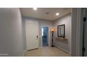 Inviting entryway with a white front door, neutral walls, light tile flooring, and a decorative mirror at 8419 S 40Th Dr, Laveen, AZ 85339