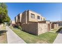 Stucco townhome featuring a well-manicured lawn, courtyard wall, and inviting surroundings at 948 S Alma School Rd # 97, Mesa, AZ 85210