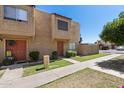 Quaint townhome with a well-maintained lawn, stucco exterior, and inviting front entrance at 948 S Alma School Rd # 97, Mesa, AZ 85210
