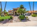 Inviting two-story home boasting a lush lawn, stone accents, and a charming stone walkway to the front door at 10386 N 96Th Pl, Scottsdale, AZ 85258