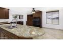 Granite countertop island with a stainless steel sink and plenty of cabinets in the kitchen at 1059 E Broadmor Dr, Tempe, AZ 85282