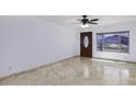Well-lit living room with tile floors, a window and a dark wood door at 1059 E Broadmor Dr, Tempe, AZ 85282