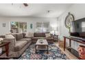 Inviting living room with a large sectional sofa, bright window, and a statement clock above the television at 1142 E Mayfield Dr, San Tan Valley, AZ 85143