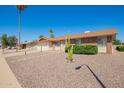 Inviting single-story home with desert landscaping, a brick facade, and a well-manicured lawn at 11627 S Iroquois Dr, Phoenix, AZ 85044