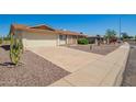 Well-maintained single-story home featuring desert landscaping and a spacious driveway on a sunny day at 11627 S Iroquois Dr, Phoenix, AZ 85044