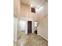 Inviting entryway with high ceilings, tile flooring, and a modern light fixture at 12029 W Overlin Ln, Avondale, AZ 85323