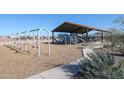 Community playground featuring swings, slides, and a covered play area with seating nearby at 17380 W Jessie Ln, Surprise, AZ 85387