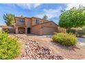 Lovely two-story home with a two car garage and desert landscaping in the front yard at 17851 W Calavar Rd, Surprise, AZ 85388