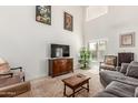 Comfortable living room featuring a plush sofa, patterned rug, and a flat-screen television at 17851 W Calavar Rd, Surprise, AZ 85388
