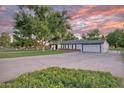 Expansive property featuring a well-maintained lawn, mature trees, and a long driveway leading to an attached garage at 1886 S 141St Pl, Gilbert, AZ 85295