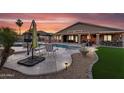 Resort-style backyard featuring a sparkling pool, patio seating, and lush landscaping perfect for entertaining at 19903 E Augustus Ave, Queen Creek, AZ 85142