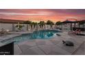 Backyard pool with inviting lounge area, lush landscaping, and a relaxing patio space for outdoor entertainment at 19903 E Augustus Ave, Queen Creek, AZ 85142