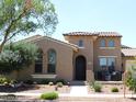 Charming two-story home featuring a tile roof, arched windows, and landscaped yard at 20453 W Daniel Pl, Buckeye, AZ 85396