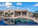 Inviting backyard pool area with mature landscaping, a decorative sunburst, and a covered patio at 20453 W Daniel Pl, Buckeye, AZ 85396