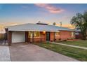 Quaint brick home with decorative ironwork, a lush lawn, and an inviting, covered carport at 2225 E Monterosa St, Phoenix, AZ 85016