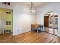 Dining room featuring wood floors, vintage chandelier, and arched doorway leading to another room at 2230 N 12Th St # Rear, Phoenix, AZ 85006