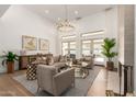 Bright living room boasts soaring ceilings, modern chandelier, neutral decor and seamless flow to the backyard at 22756 N 91St Way, Scottsdale, AZ 85255