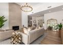 Comfortable living room features hardwood floors, soaring ceilings, elegant chandelier, and an inviting fireplace at 22756 N 91St Way, Scottsdale, AZ 85255