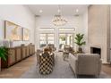 Open-concept living room boasts soaring ceilings, a modern chandelier, neutral decor, and seamless flow to the backyard at 22756 N 91St Way, Scottsdale, AZ 85255