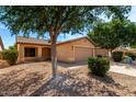 Single-story home with desert landscaping featuring a two-car garage and a cozy front porch at 30212 N Sunray Dr, San Tan Valley, AZ 85143